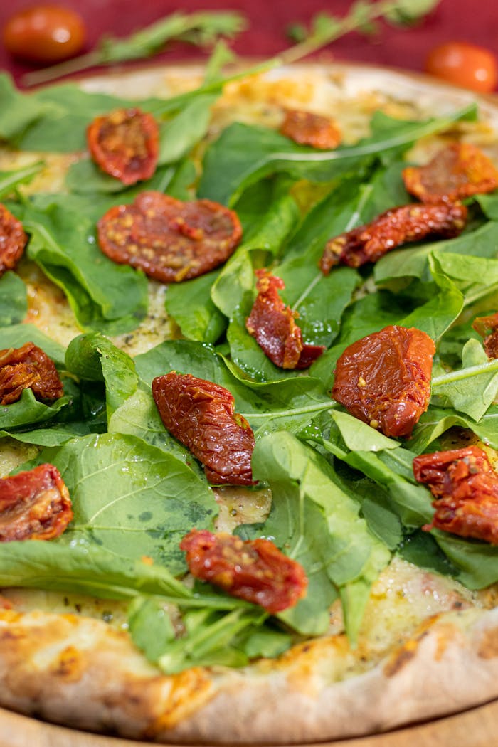 Mouth-watering pizza topped with fresh arugula and sun-dried tomatoes. Perfect for Italian cuisine enthusiasts.