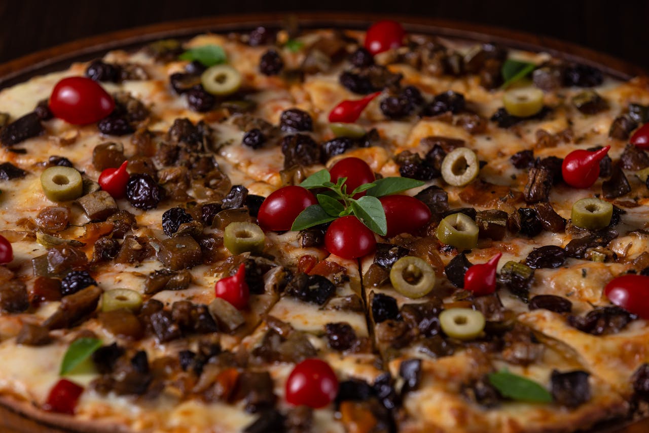 Mouth-watering Italian-style pizza topped with olives, cherry tomatoes, and cheese.